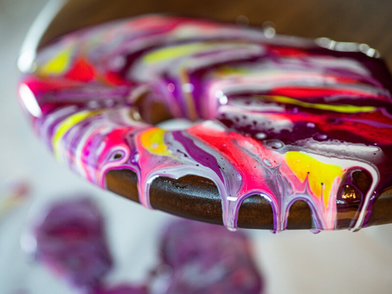 Purple, yellow and pink resin dripping over a wooden board